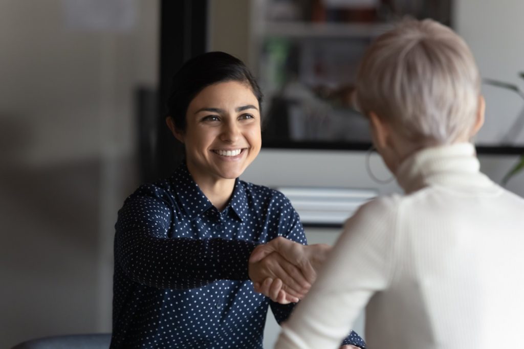 Happy employer HR manager shaking hands with job seeker welcoming vacancy applicant. Successful manager making deal with partner, good positive first impression, start business meeting concept